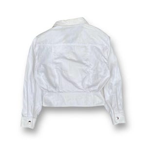 May include: White long-sleeved button-up shirt with a collared neckline and a cropped hem.