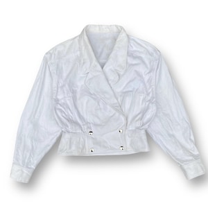 May include: A white cropped jacket with a double-breasted closure and long sleeves.