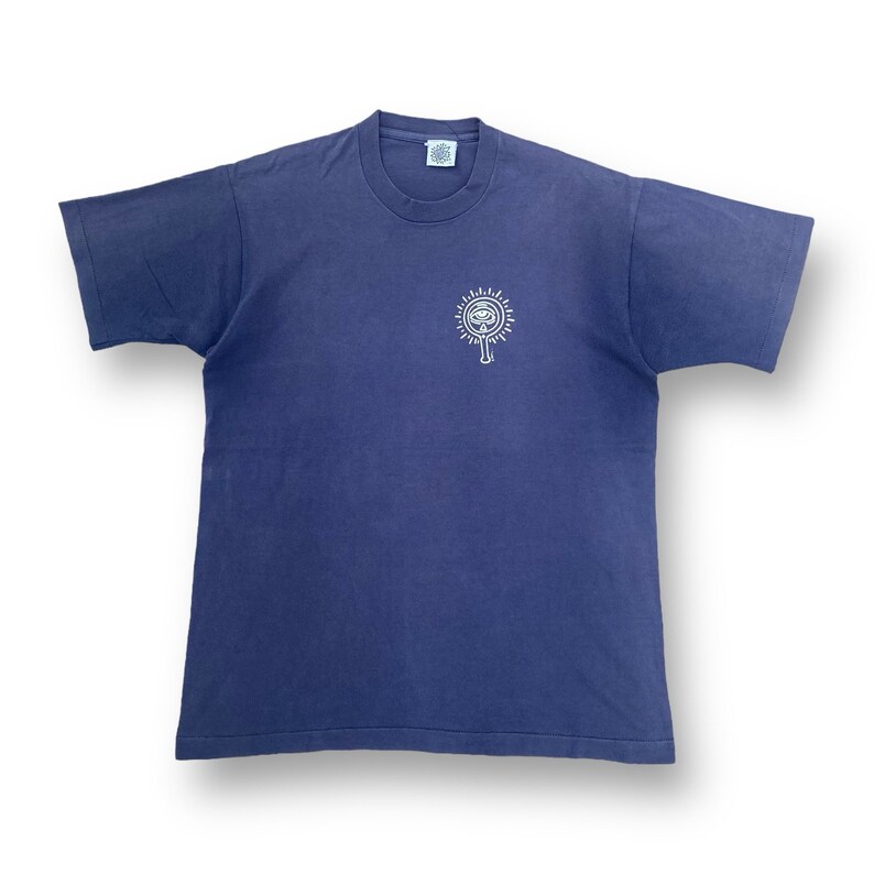 Puede incluir: Una camiseta azul oscuro de manga corta con un gr&aacute;fico blanco de un ojo estilizado con rayos de luz que emanan de &eacute;l.