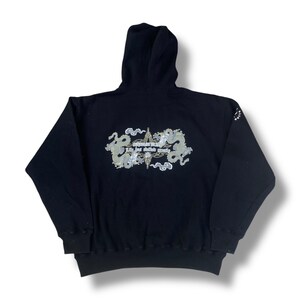 May include: Black hooded sweatshirt with a graphic print of two dragons and the text "Everything is possible, Life just takes more time".