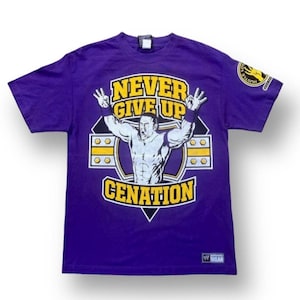 Puede incluir: Camiseta morada con un gráfico de John Cena, un luchador profesional, con el texto "Never Give Up Cenation".