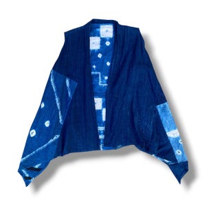May include: A sleeveless vest featuring a patchwork design in various shades of indigo blue and white. The garment displays a mix of solid dark blue panels and sections with white tie-dye patterns, including small squares and circular motifs.