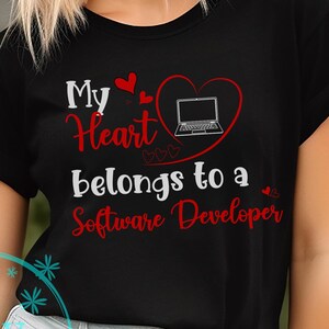 May include: Black t-shirt with the text "My Heart belongs to a Software Developer" in red and white. A red heart with a laptop graphic is above the text. The shirt is worn by a person.