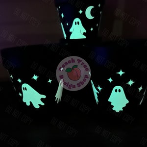 May include: Four black ceramic planters with a glow-in-the-dark design featuring ghosts, stars, and a crescent moon. The planters have a white "Peach Tree Design Shop" logo.