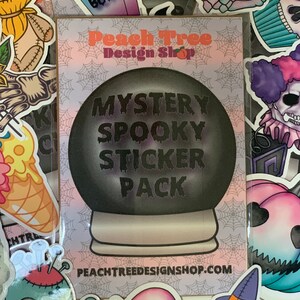 Pu&ograve; includere: Un'immagine in bianco e nero di un pacchetto di adesivi spettrali con un design a sfera di cristallo. Il testo sull'immagine recita "Mystery Spooky Sticker Pack" e "PeachTreeDesignShop.com".