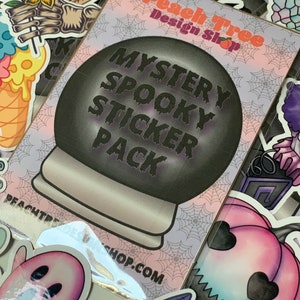 Pu&ograve; includere: Un pacchetto di adesivi con un design nero e viola che presenta una sfera di cristallo spettrale con il testo "Mystery Spooky Sticker Pack". Il pacchetto di adesivi &egrave; di Peach Tree Design Shop.