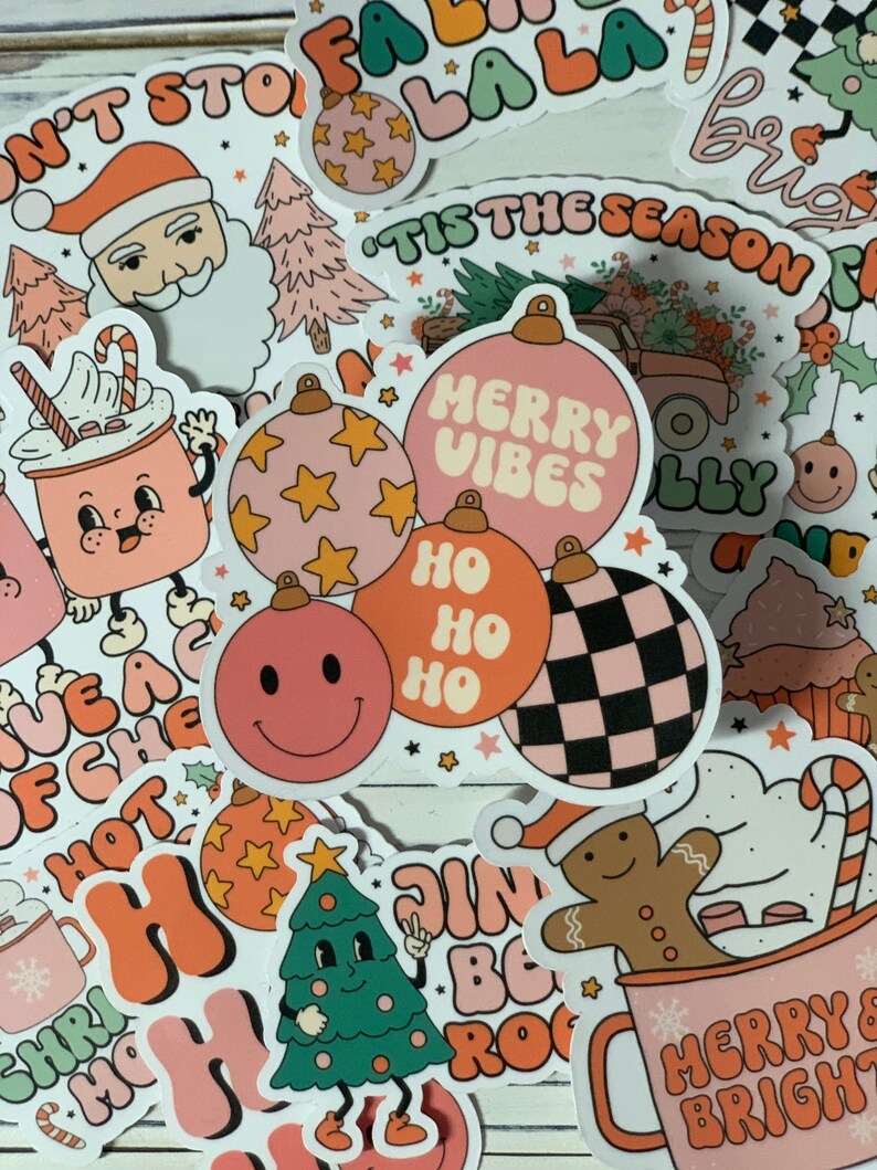 May include: A collection of Christmas-themed stickers featuring various designs, including a Santa Claus, a Christmas tree, ornaments, and a gingerbread man. The stickers are in a retro style with bright colors and bold fonts. The text on the stickers includes "Merry Vibes", "Ho Ho Ho", "Tis the Season", and "Merry & Bright".