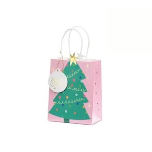 Könnte beinhalten: Eine rosa Geschenkverpackung mit einem grünen Weihnachtsbaum-Design. Der Baum ist mit bunten Lichtern und einem goldenen Stern verziert. Die Tasche hat weiße Griffe und ein weißes Etikett mit "Merry Christmas".