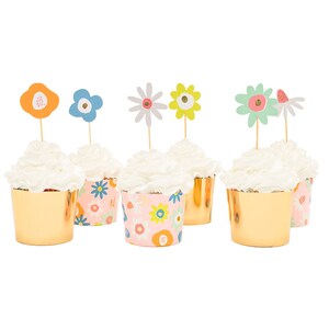 May include: Six gold cupcake cases with pink and white floral patterns and white icing topped with colourful paper flower picks.