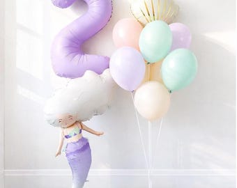 Conjunto de balões em tons pastel com tema "Pequena Sereia" para festa de aniversário com conchas, ideal para chá de bebê ou festa temática do oceano. Inclui balões metalizados roxos com números.