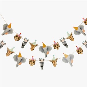 May include: A colorful party garland featuring animal faces with party hats. The garland includes a zebra, giraffe, elephant, and leopard. The garland is perfect for a safari-themed party.