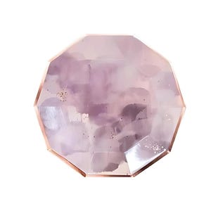 Op de afbeelding: Een grote, gefacetteerde, roze edelsteen met een gouden metalen rand. De edelsteen heeft een troebele, doorschijnende uitstraling.