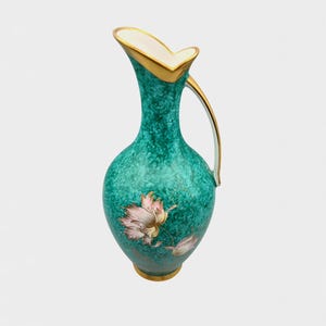 Könnte beinhalten: Eine Vintage-Krug in Smaragdgrün mit strukturierter Oberfläche und Goldrand. Die Kanne hat ein zartes Blumendesign in Rosa und Gold. Der Griff und der Rand sind mit Gold akzentuiert.