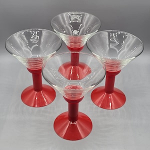 Peut inclure: Un ensemble de quatre verres à martini en verre transparent, chacun doté d'un pied en plastique rouge vif et d'une base circulaire rouge. Les bols sont transparents avec un design lisse à large bord, soutenus par un pied cylindrique rouge.