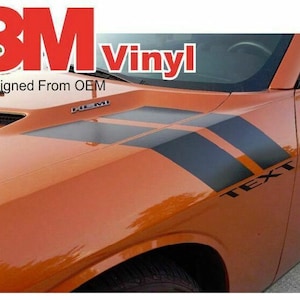 Puede incluir: Dodge Challenger naranja con rayas laterales de vinilo negro y el texto "TEXT" en el lateral. El coche tiene un logotipo de 3M y el texto "Designed From OEM" en la parte delantera.
