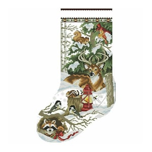 Peut inclure: Une chaussette de Noël représentant une scène de forêt hivernale. Un cerf, un écureuil, des oiseaux et un raton laveur sont représentés dans un paysage enneigé. Une lanterne rouge est posée près du cerf. Le haut de la chaussette a un motif géométrique.