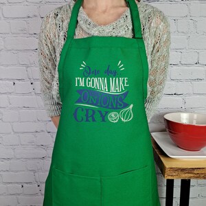 May include: Green apron with a white and blue design that says "One day... I'm gonna make these onions cry".
