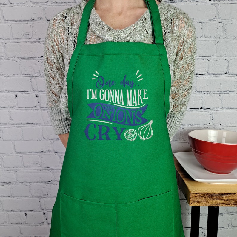 May include: Green apron with a white and blue design that says "One day... I'm gonna make these onions cry".