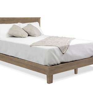 May include: A wooden bed frame with a white mattress and two pillows. The bed frame is a light brown color and has a simple design.