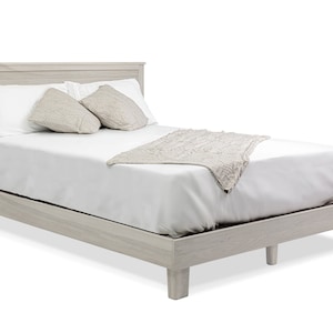 May include: A white wooden platform bed frame with a white mattress, two white pillows, and a beige throw blanket.