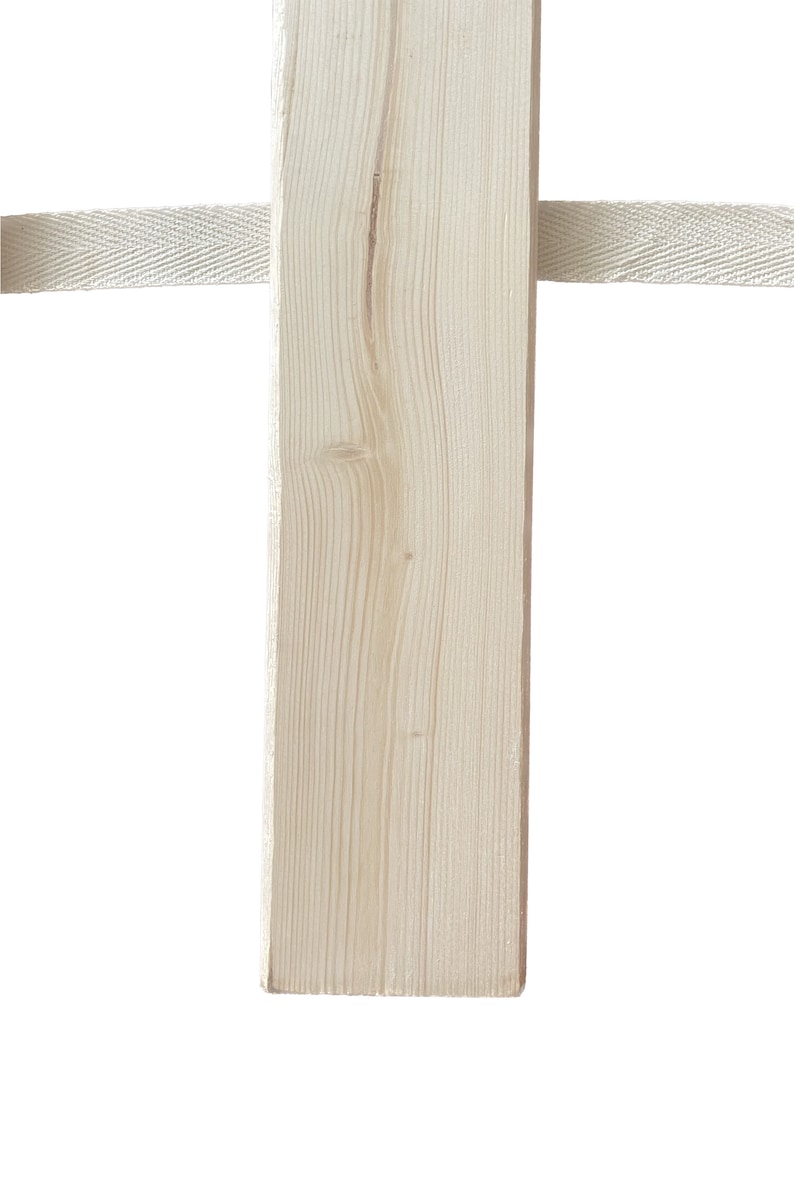 May include: A close-up of a light brown wooden post with a white fabric strap wrapped around it.
