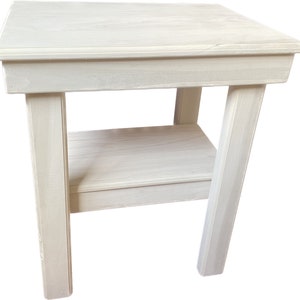 May include: White wooden end table with a single shelf. The table has a simple, farmhouse style.
