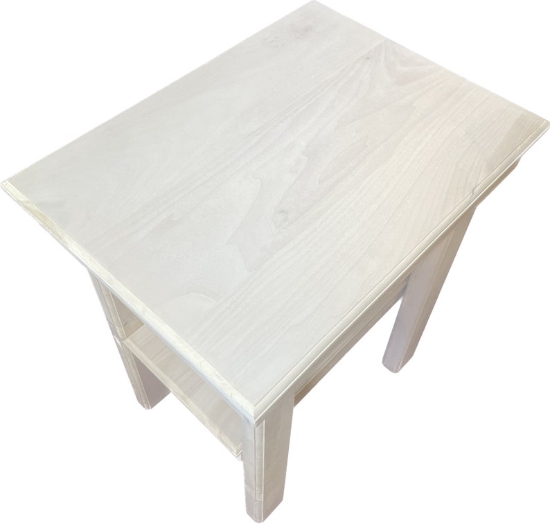 May include: White wooden end table with a shelf. The table has a simple design with a rectangular top and legs.