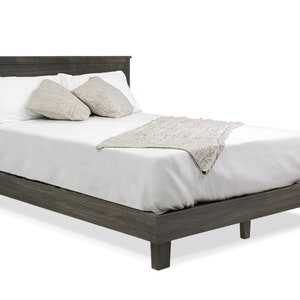 May include: A gray wooden platform bed frame with a white mattress, white pillows, and a white throw blanket.