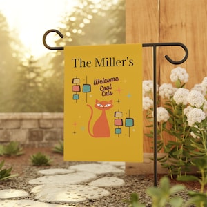 May include: A yellow garden flag with a red cat and the text "The Miller's Welcome Cool Cats" in black lettering.