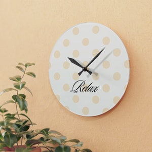 May include: White clock with black hands and beige polka dots. The clock face says "Relax".