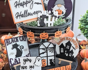 Könnte beinhalten: Ein dreistufiges Tablett, das mit verschiedenen Schildern für Halloween dekoriert ist, darunter "Happy Halloween", "Black Cat", "You are my boo" und "Happy Haunting". Außerdem gibt es einen Gnom, eine schwarze Katze, ein Fenster und eine Kürbisgirlande.