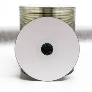 May include: A stack of blank, white, recordable compact discs (CDs) with a single CD in the front.