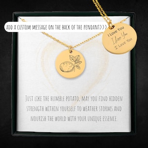 May include: Gold necklace with a round pendant featuring a line drawing of a potato plant. The pendant is in a box with a message that reads "Just like the humble potato, may you find hidden strength within yourself to weather storms and nourish the world with your unique essence."