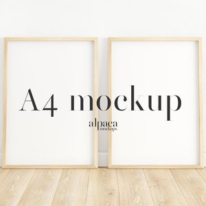 Könnte beinhalten: Zwei A4-Mockups in Holzrahmen auf einem hellen Holzboden vor einer weißen Wand. Der Text "A4 mockup" und "alpaca mockups" ist auf den Rahmen sichtbar.
