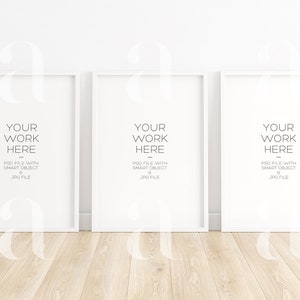 Puede incluir: Tres marcos de fotos blancos con paspartús blancos y un fondo blanco. Los marcos están dispuestos en una fila, con el marco de la izquierda ligeramente más cerca del espectador. El texto "YOUR WORK HERE" está impreso en gris en cada marco. El texto "PSD FILE WITH SMART OBJECT & JPG FILE" está impreso en gris debajo del texto "YOUR WORK HERE" en cada marco.