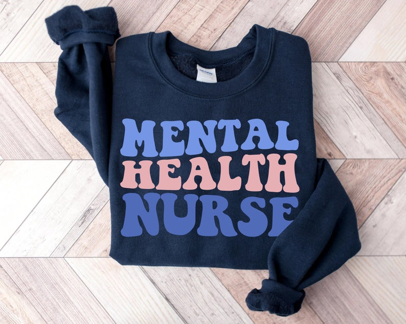 May include: A navy blue sweatshirt with the text "MENTAL HEALTH NURSE" in pink, blue, and purple retro-style lettering.