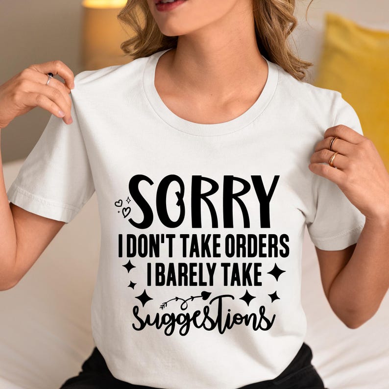 May include: White t-shirt with black text that reads "Sorry I don't take orders I barely take suggestions". The text is surrounded by small hearts and stars.