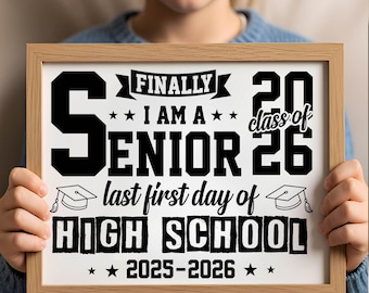 May include: A framed sign with the text "Finally I am a Senior Class of 26, last first day of High School 2025-2026" in black font on a white background. The frame is made of light brown wood.