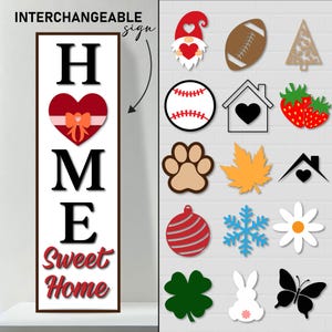 May include: Interchangeable "HOME Sweet Home" sign with a red heart and a bow. The sign has a variety of interchangeable decorations, including a gnome, a football, a Christmas tree, a baseball, a house, strawberries, a paw print, a maple leaf, a roof with a heart, an ornament, a snowflake, a daisy, a four-leaf clover, a bunny, and a butterfly.