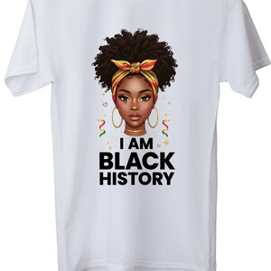 Peut inclure: T-shirt blanc avec un graphisme représentant une femme noire aux cheveux bouclés, des créoles dorées et un foulard coloré. Le texte "I AM BLACK HISTORY" est imprimé en dessous de l'illustration en lettres noires grasses.