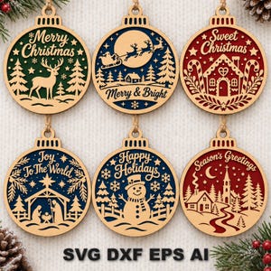 May include: Six circular wooden Christmas ornaments featuring laser-cut designs. The ornaments display scenes including a reindeer, Santa in a sleigh, a gingerbread house, a nativity, a snowman, and a village, with text like Merry Christmas.