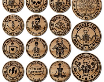 May include: A collection of round, wooden magnets with black engraved designs and text. The magnets feature humorous phrases and skeleton illustrations. The text includes phrases like "I'm not ignoring, I'm resting" and "My blood type is coffee only."