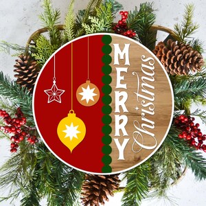May include: A Christmas wreath with a wooden sign that says "MERRY Christmas". The sign is red and brown with hanging star and ornament decorations. The wreath is decorated with pinecones, red berries, and evergreen branches.