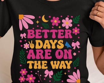 May include: Black t-shirt with a pink, yellow, and green floral design. The text "Better Days Are On The Way" is printed in pink and yellow.