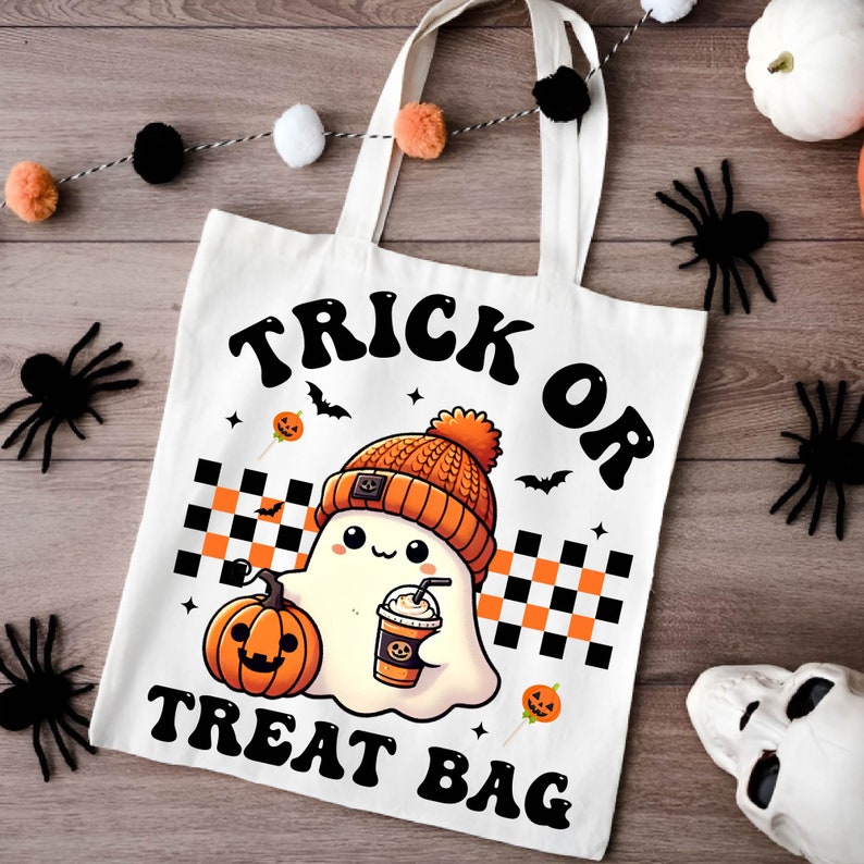 May include: White canvas tote bag with black text that reads "Trick or Treat Bag". A cartoon ghost wearing a beanie hat and holding a pumpkin spice latte is in the center of the bag.