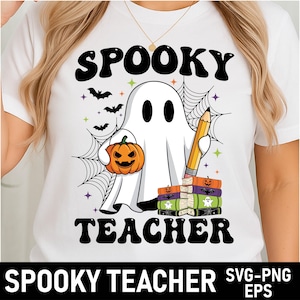 May include: White t-shirt with a Halloween-themed graphic. The design features a ghost holding a jack-o'-lantern and a pencil, with the words "Spooky Teacher" in black. Bats and spiderwebs complete the design.