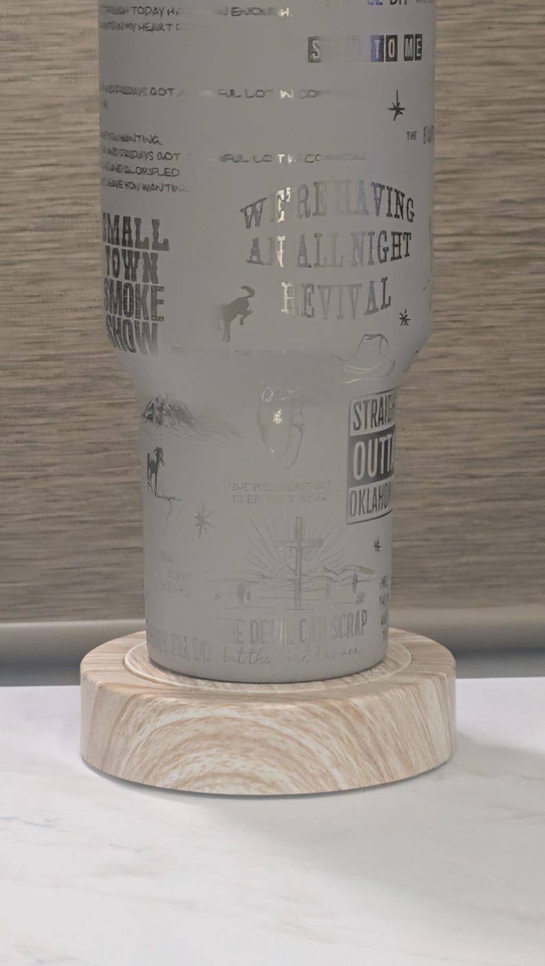 Może przedstawiać: Mrożony kubek z wytrawionymi wzorami i tekstem, w tym "We're Having An All Night Revival" i "Small Town Smoke Show". Kubek stoi na jasnej drewnianej podstawce. Projekt zawiera gwiazdy, kapelusz kowbojski i konia.