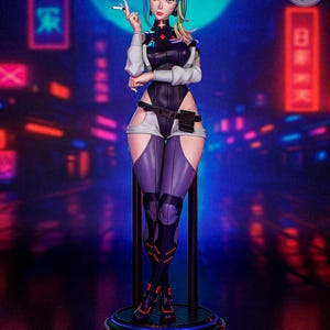 May include: A detailed figurine of a female character with rainbow-colored hair, wearing a black and white bodysuit, purple leggings, and black boots. The figure is holding a cigarette, set against a neon-lit cityscape backdrop.