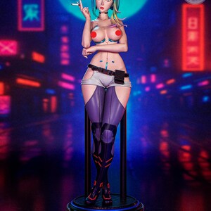 May include: A detailed figurine of a female character with a futuristic aesthetic. The figure has colorful hair, a cigarette, and is wearing a revealing outfit with purple and white accents. The base has the word "Cyberpunk" and the website "www.patreon.com/peachfigure".