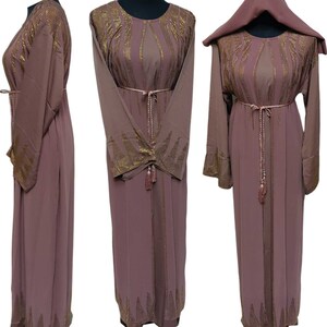 May include: A mauve abaya with gold embellishments and a matching belt. The abaya has long sleeves and a flowing silhouette.